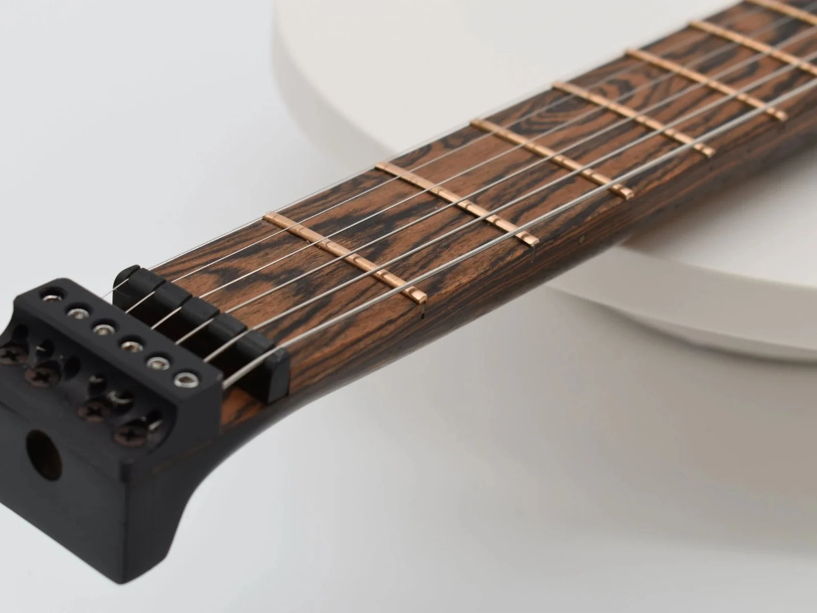 Close view of the string lock at the end of an Anesidora headless guitar neck